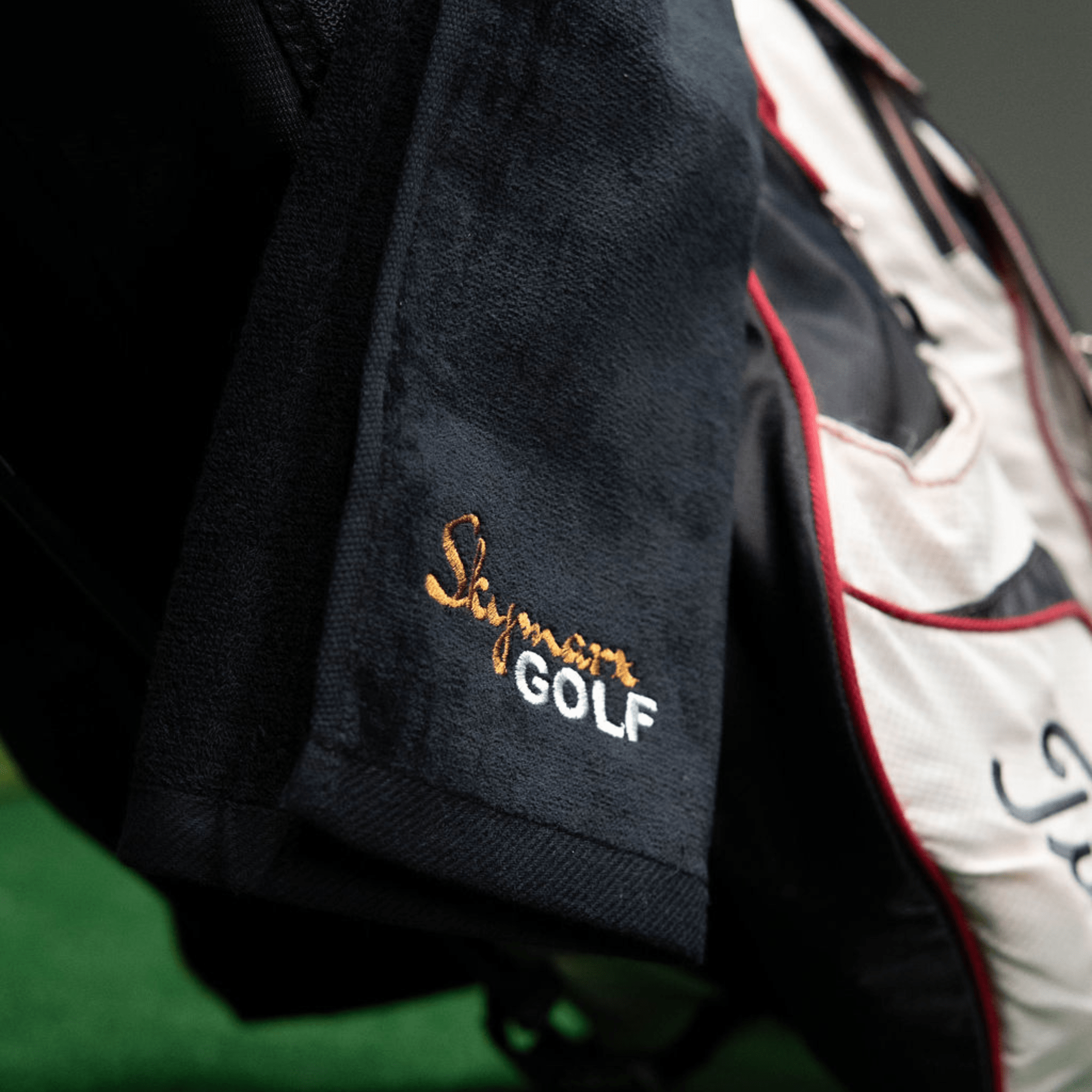 musta golf mailapyyhe roikkumassa golfbägissä