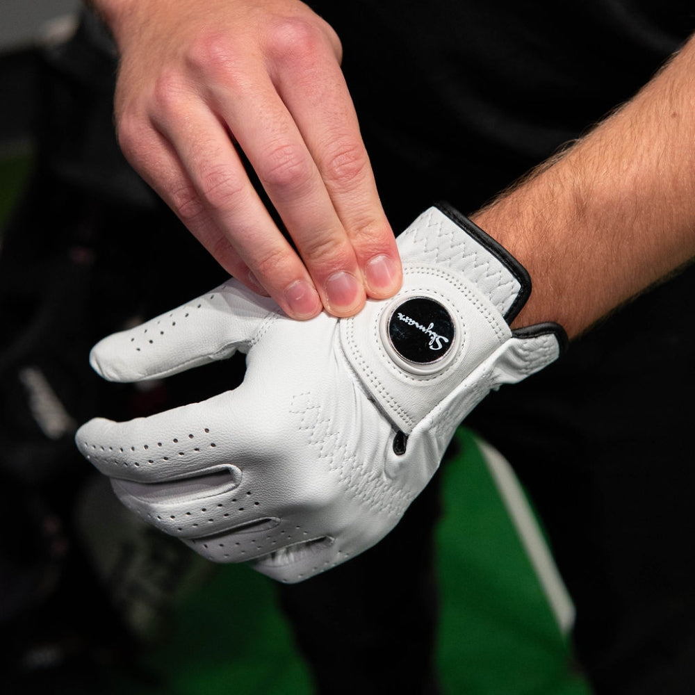 cabretta marker golfhanska golfarin kädessä